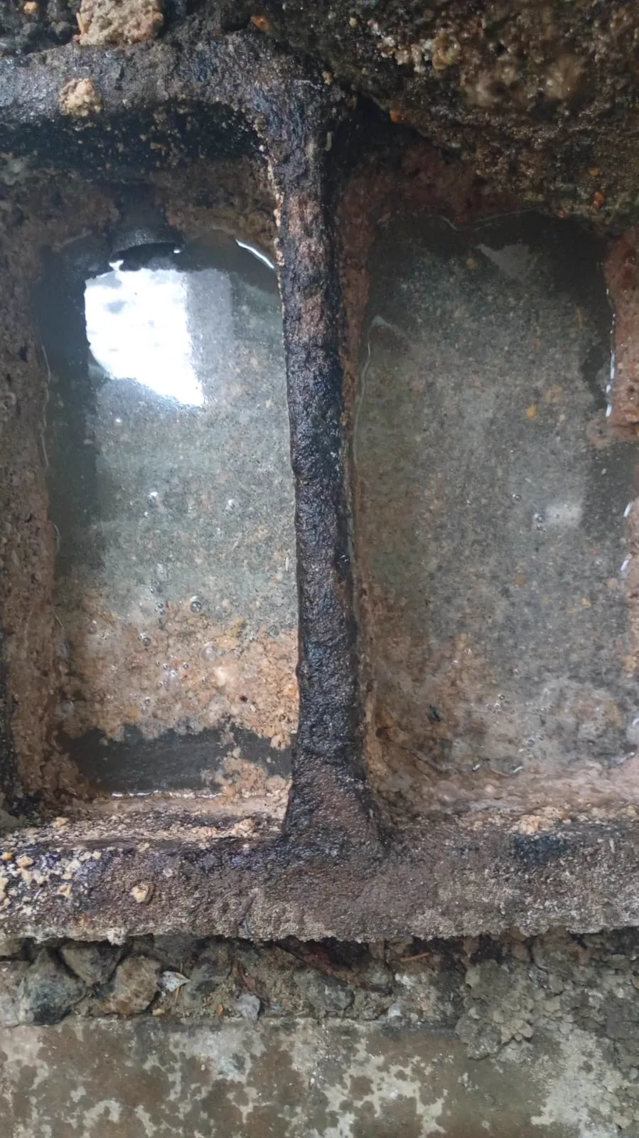 Caixa de gordura de alvenaria com duas câmaras separadas por uma parede, as duas com água à vista