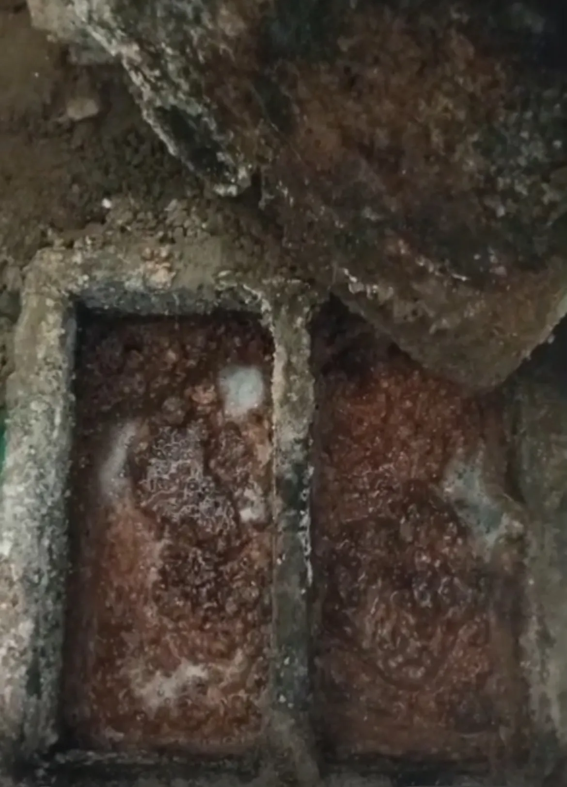 Caixa de gordura de alvenaria com duas câmaras tomadas por uma crosta grossa de gordura marrom