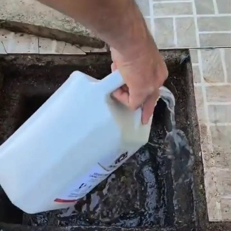 Aplicação de produto direto na caixa de gordura saturada, com o galão despejando sobre a camada de gordura